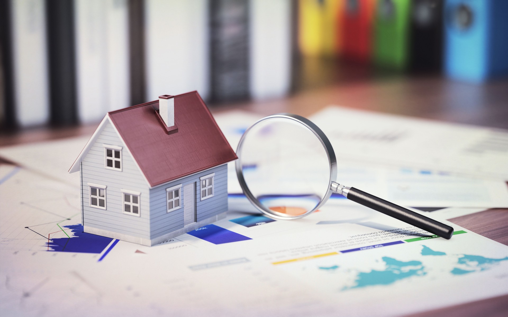 Miniature House and Magnifier with Financial Graphic Studies